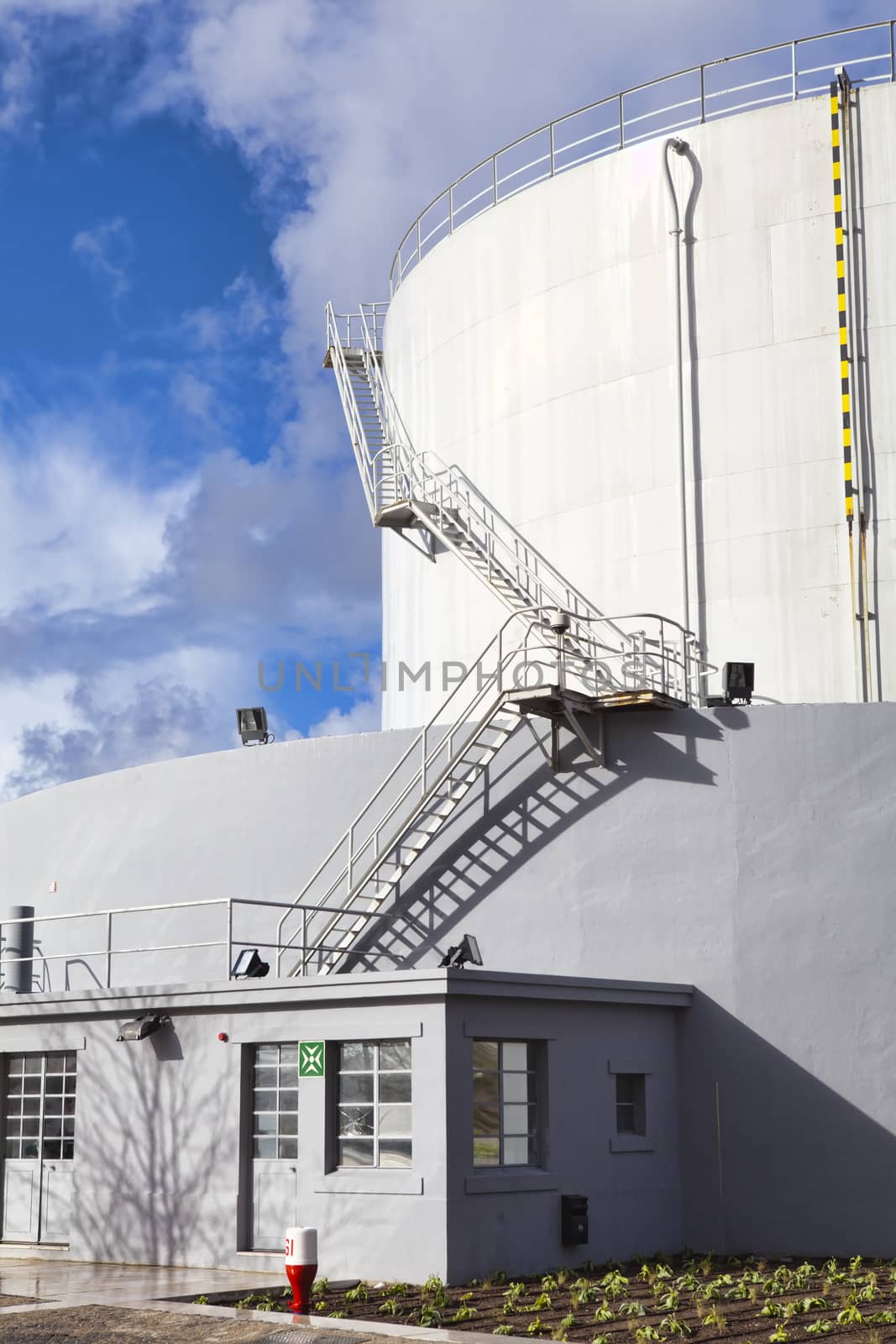 White tanks in tank farm with iron staircase 