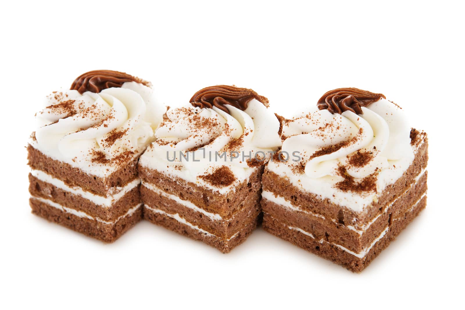 Chocolate biscuit cake decorated with cream flowers isolated on white background