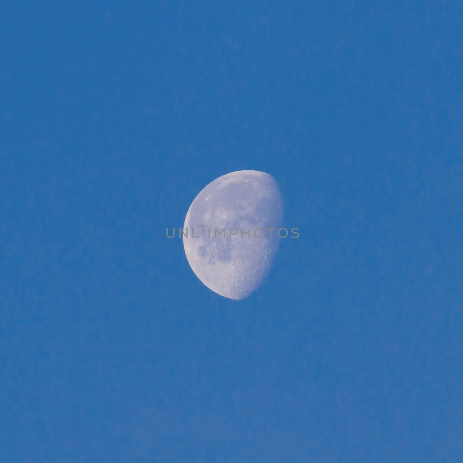 Waxing Gibbous Moon in blue sky showing craters