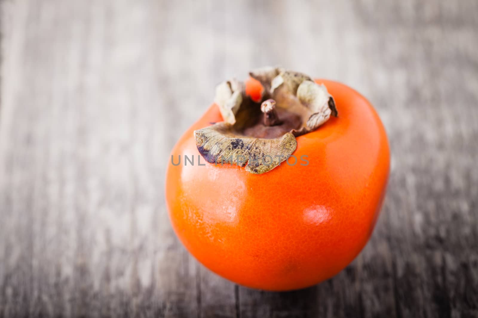 Fresh Juicy Persimmon on a wooden table