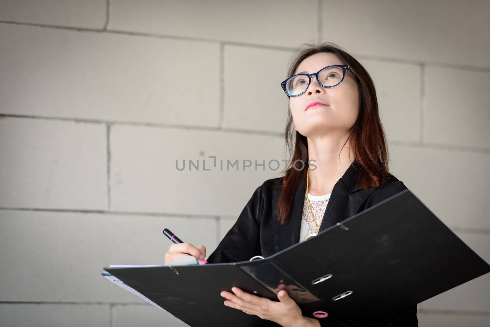 Businesswoman is writing a report in a brick building.