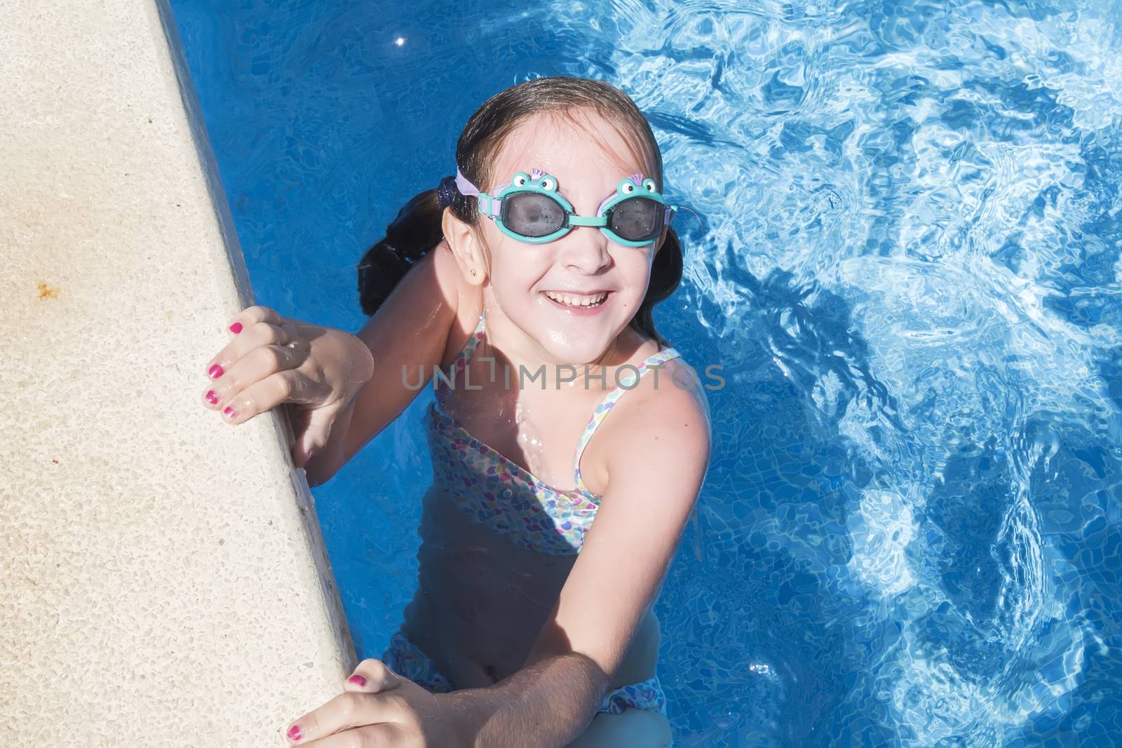 Smiling girl enjoying the pool in summer