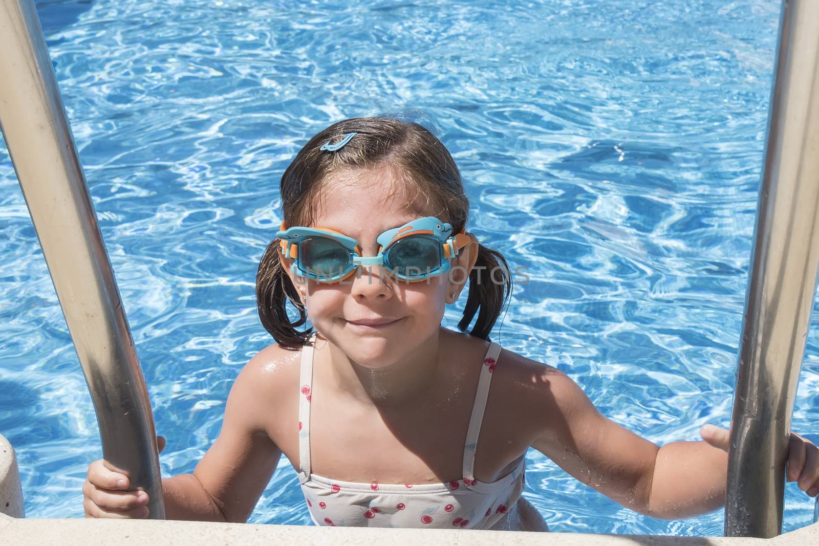 Smiling girl enjoying the pool in summer