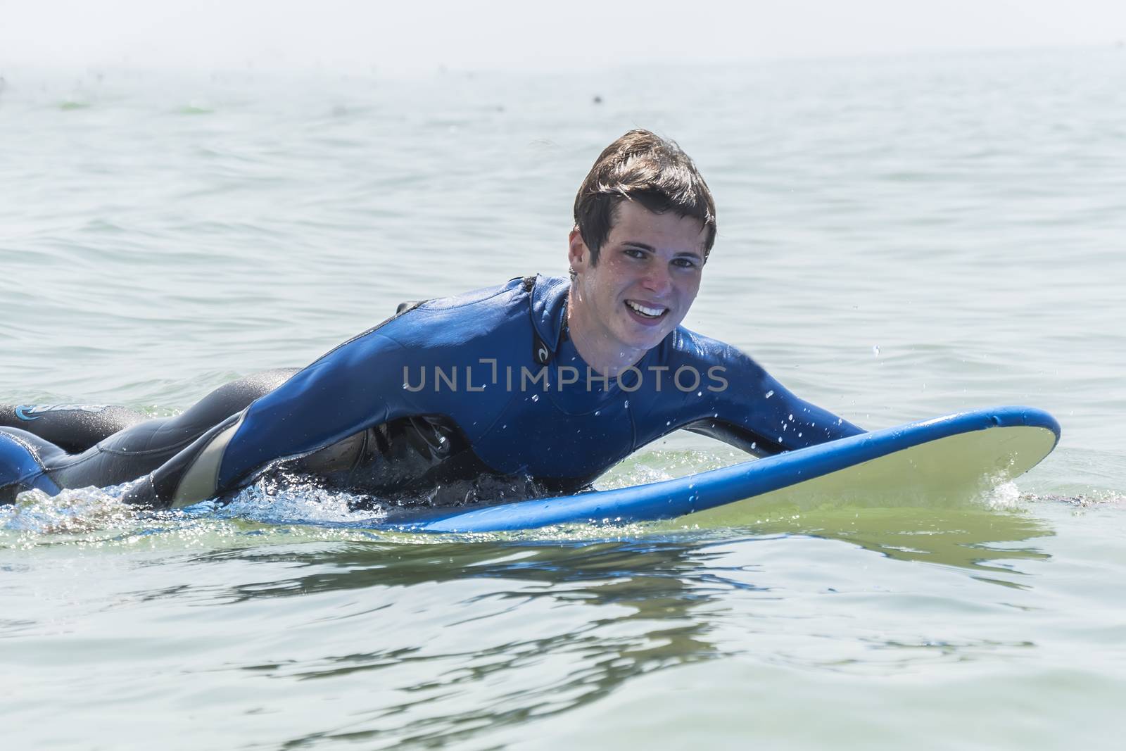 Young boy surfing in the sea, smiling