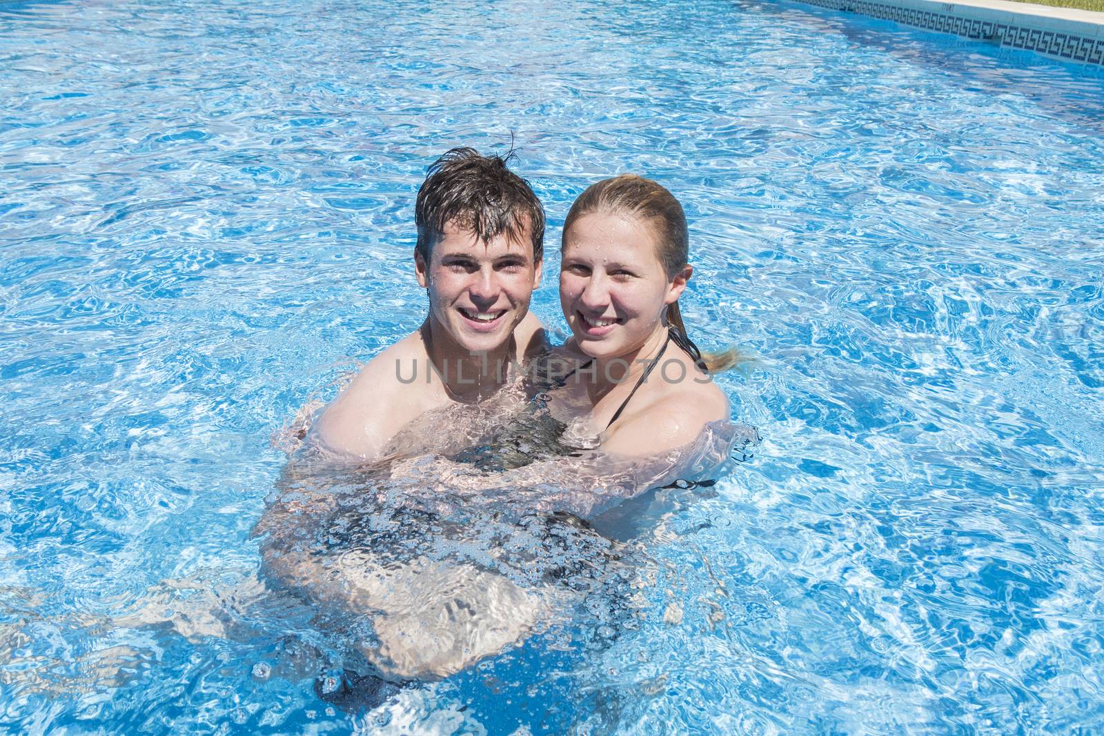 Smiling young couple enjoying the pool in summer by max8xam