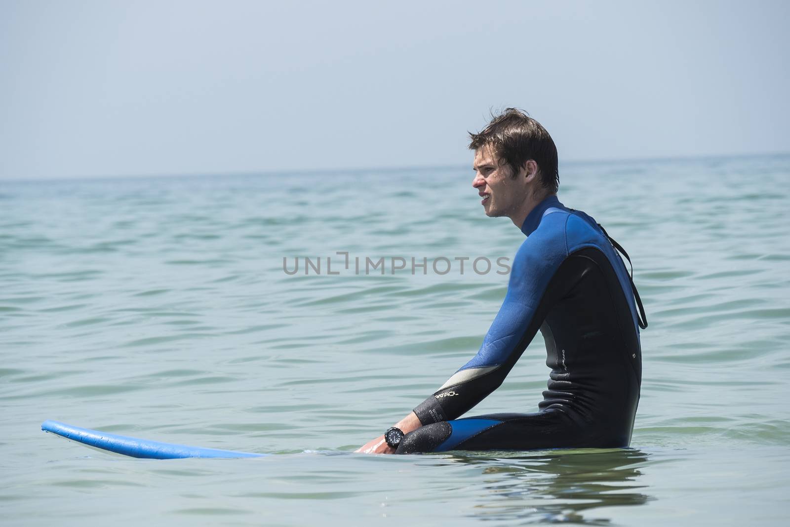 Young boy surfing in the sea, waiting waves