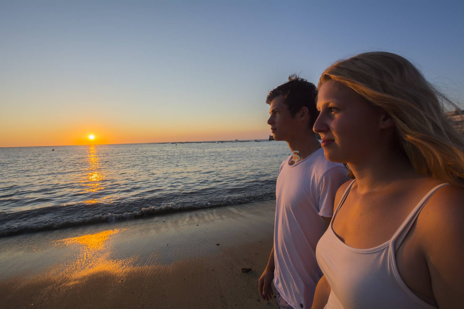 Couple watching the sunset on the beach by max8xam
