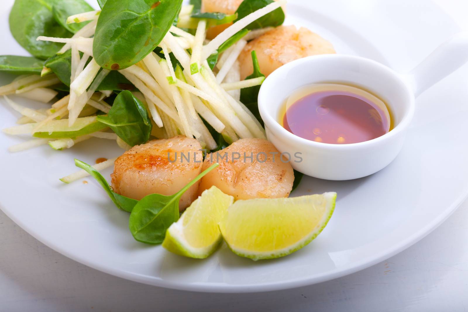 Scallop Salad with greenery served on a white plate