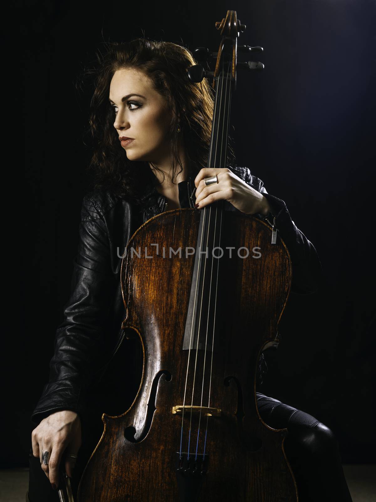 Photo of a beautiful woman posing with her old cello.