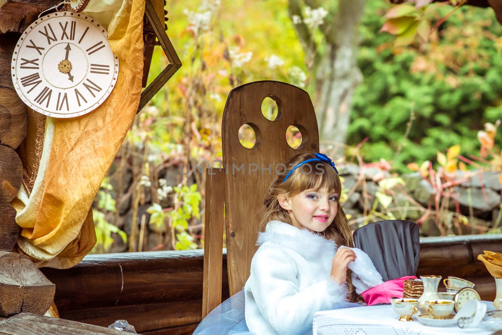 An little beautiful girl holding cylinder hat with ears like a rabbit in the hands at the table by okskukuruza