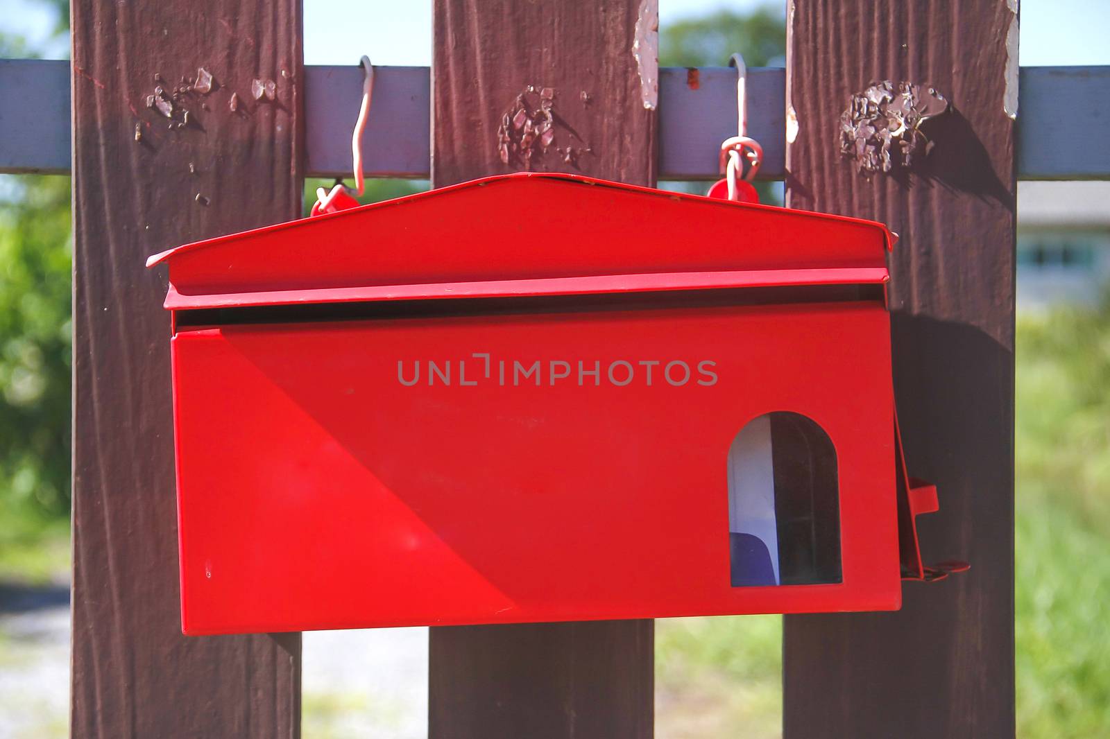 Red mailbox on brown gates front of house