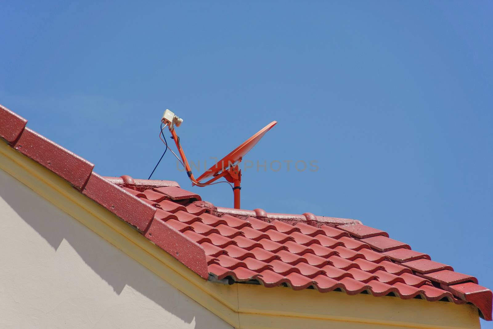 red roof with a satellite dish and blue sky