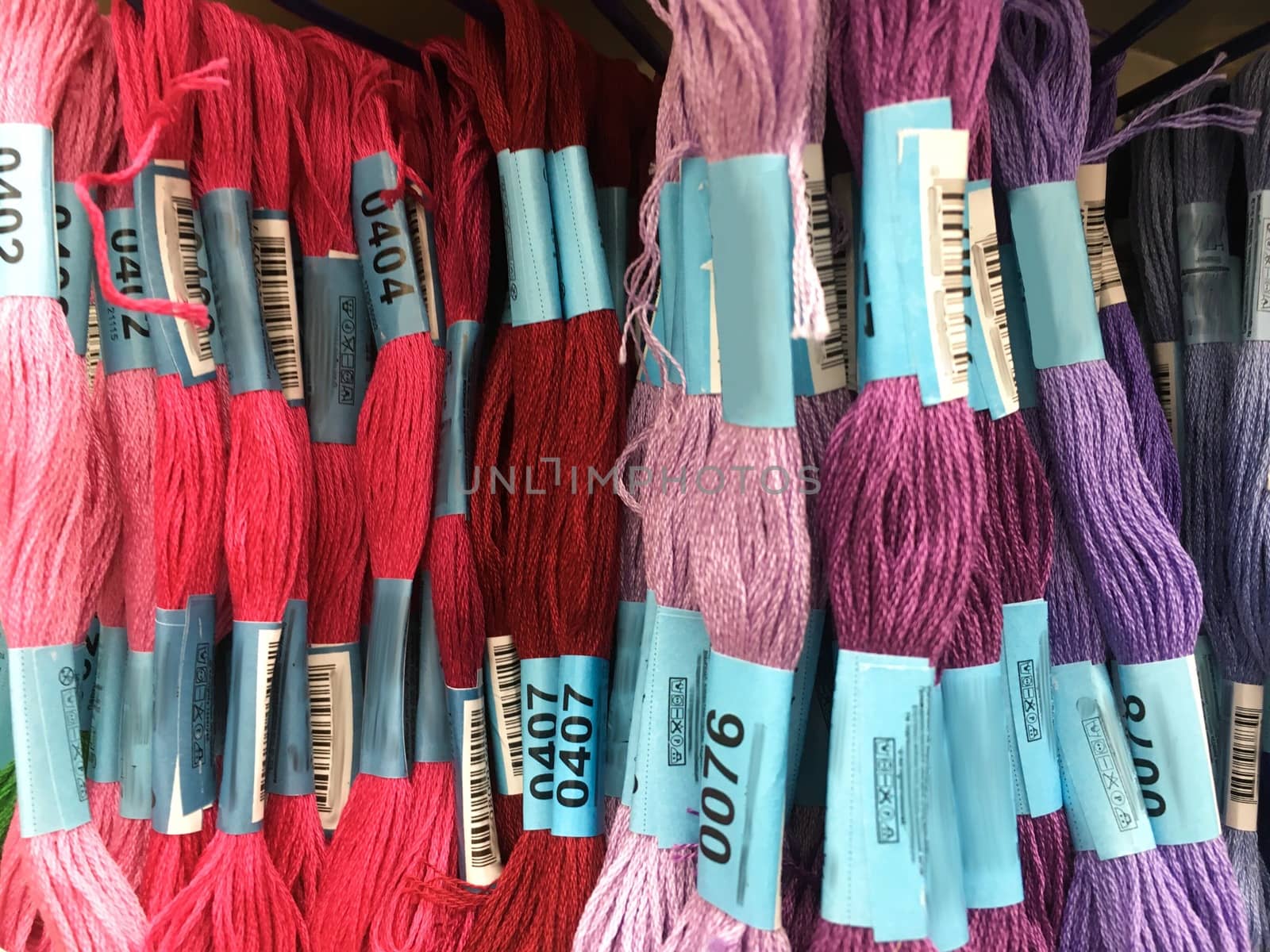 sewing threads for embroidery  view on sewing shop shelves with various knitting yarn, Numbered samples colored threads