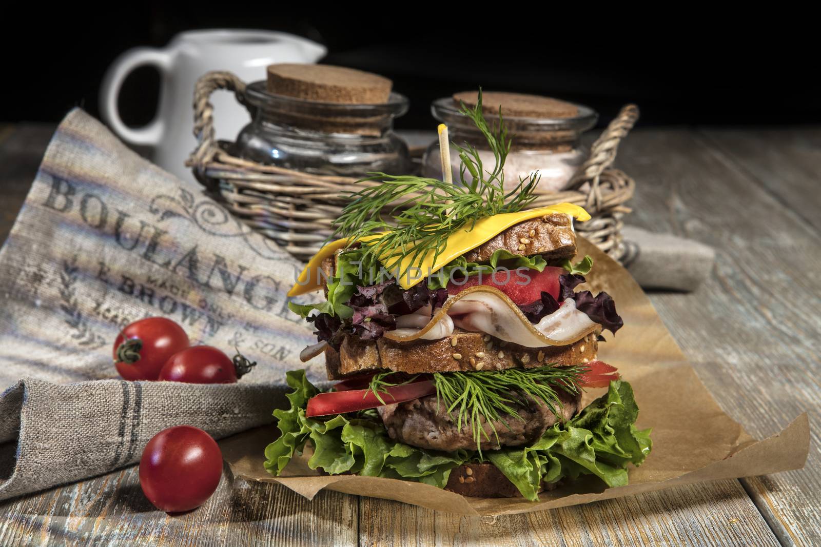 Sandwich with vegatables and tomatoes on an old wooden table