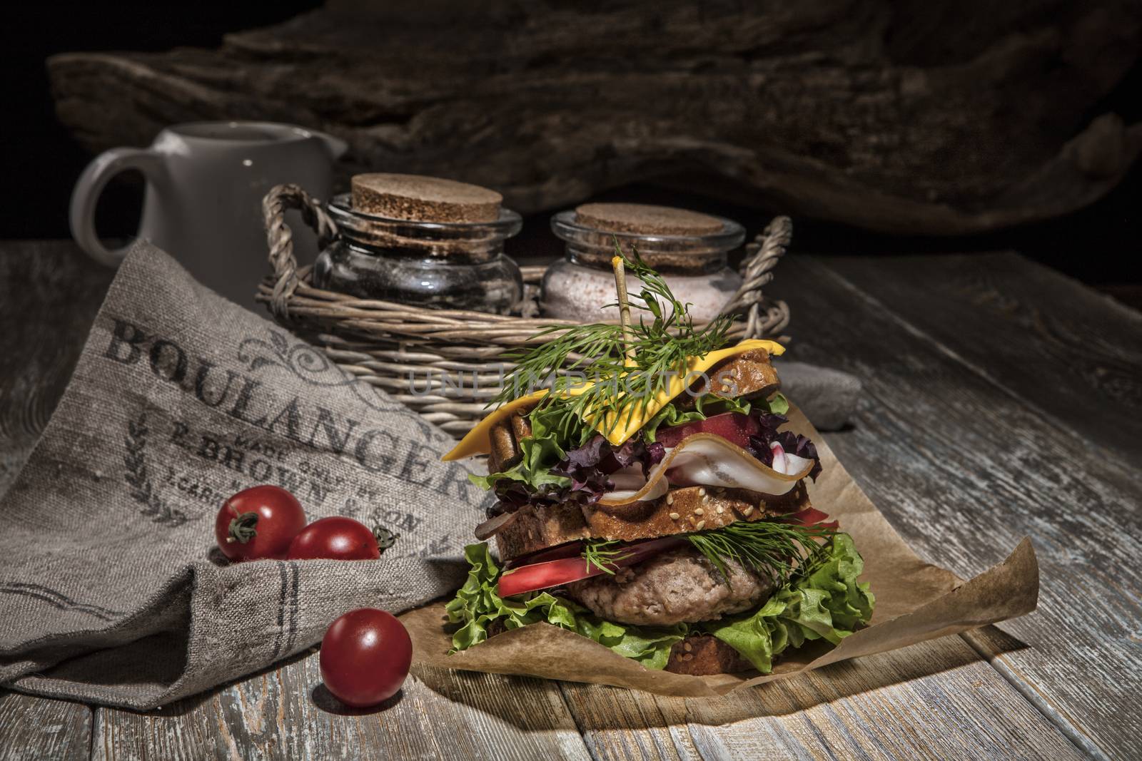 Sandwich with vegatables and tomatoes on an old wooden table