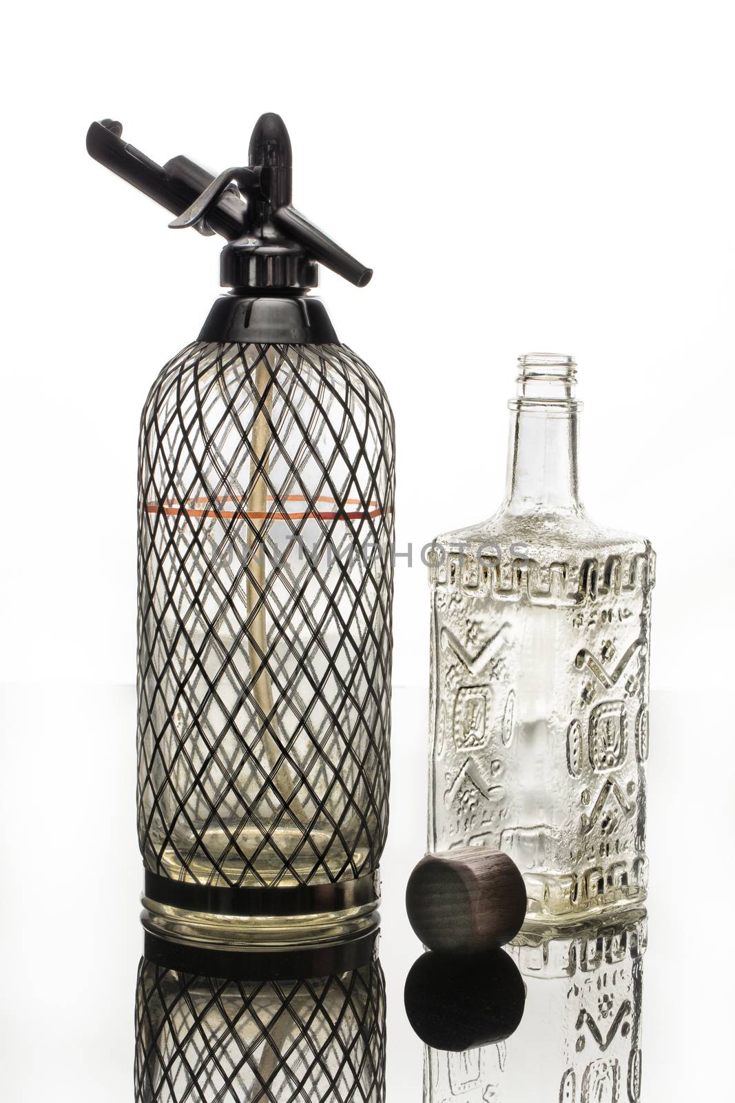Siphon, bottle and tap on a glass studio background