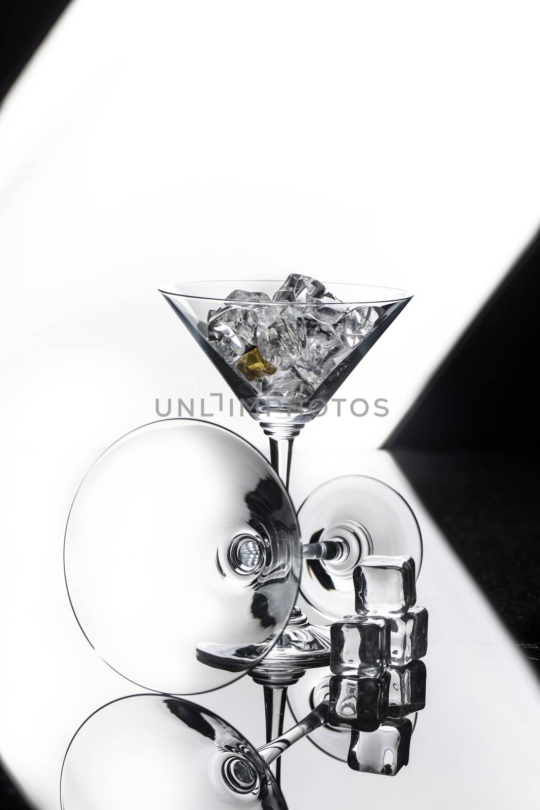Two glasses and crystals of ice on a glass studio background