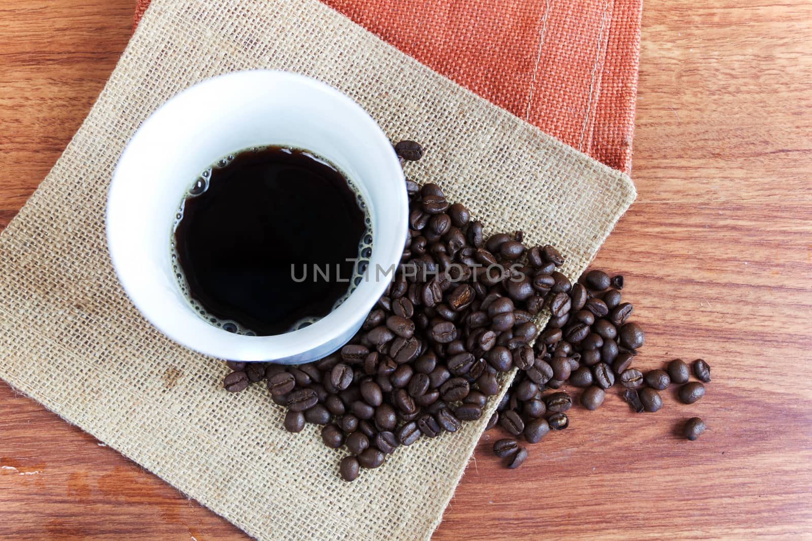 Black hot coffee in white cup and coffee bean on wood table