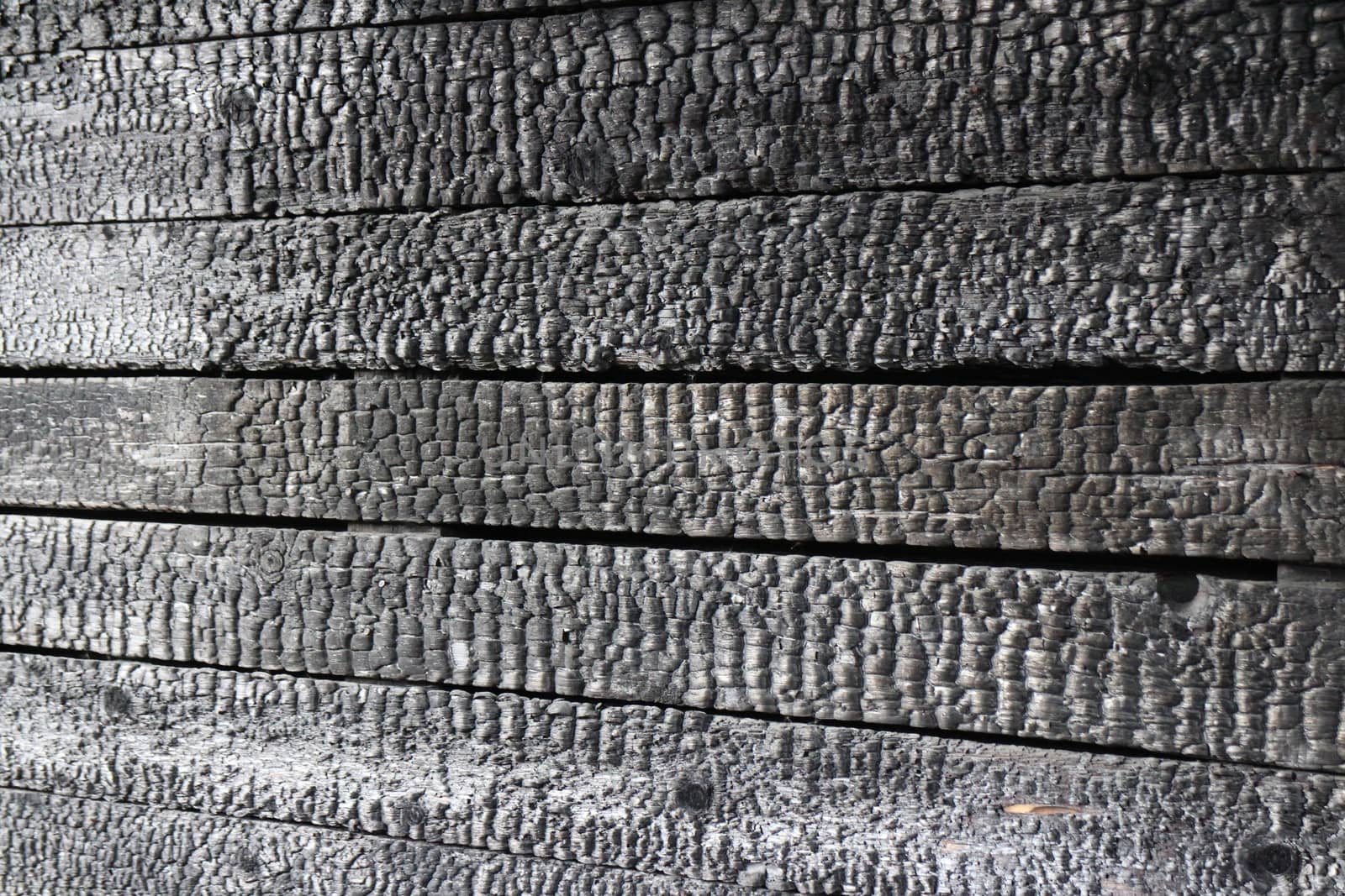 Charred wooden wall after  fire arson, Abstract black background