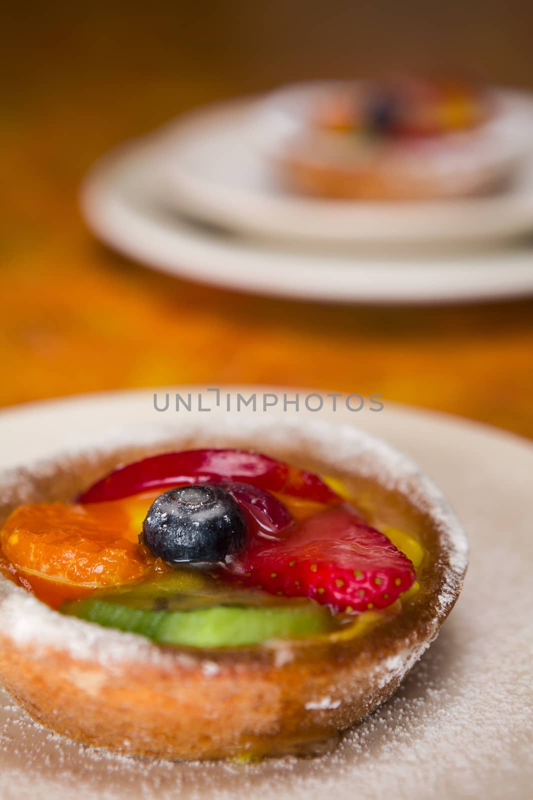 Fruit tart on a plate over a colored table