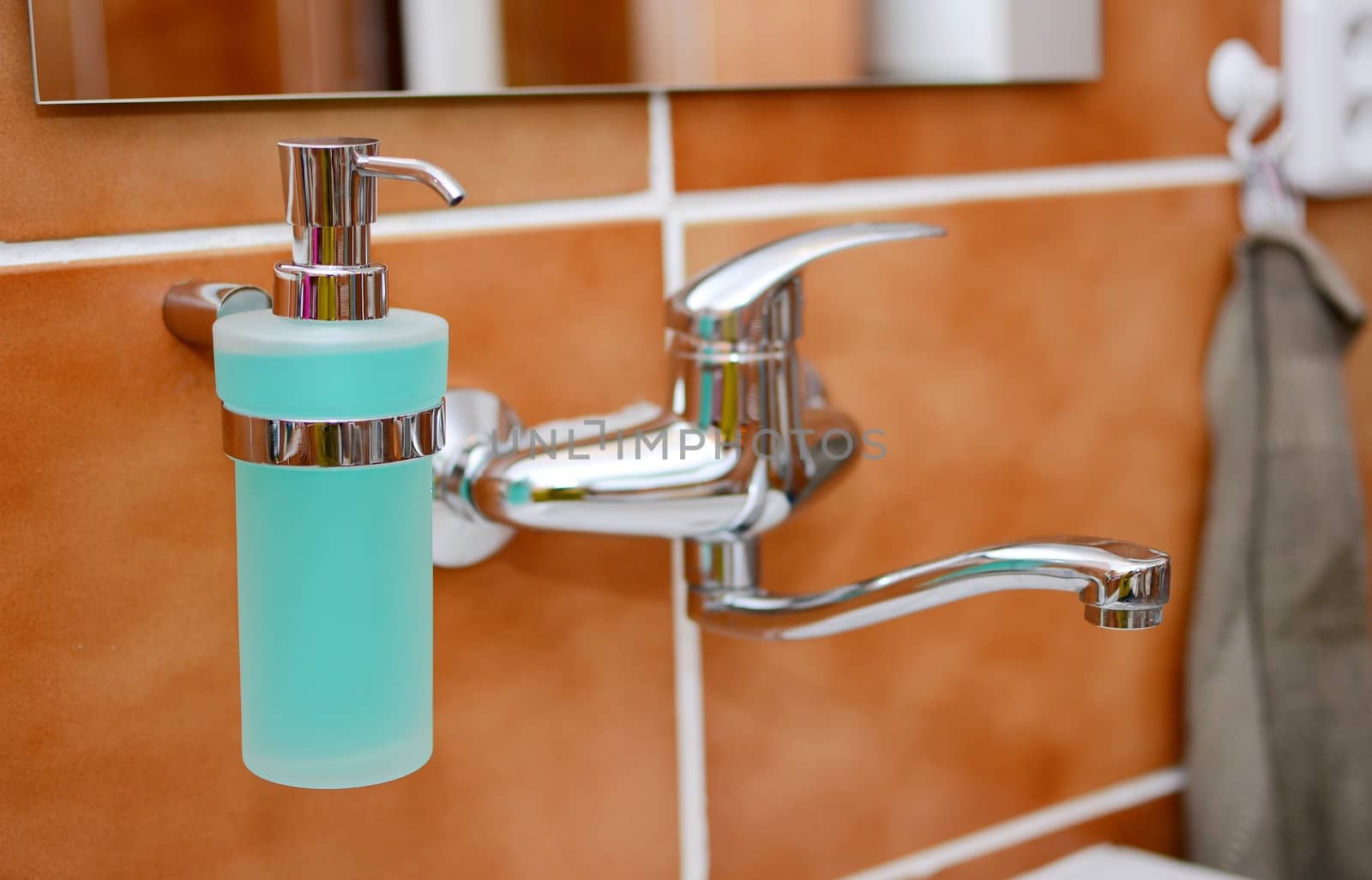 Closeup of a Soap Dispenser and Other Equipment in Bathroom.