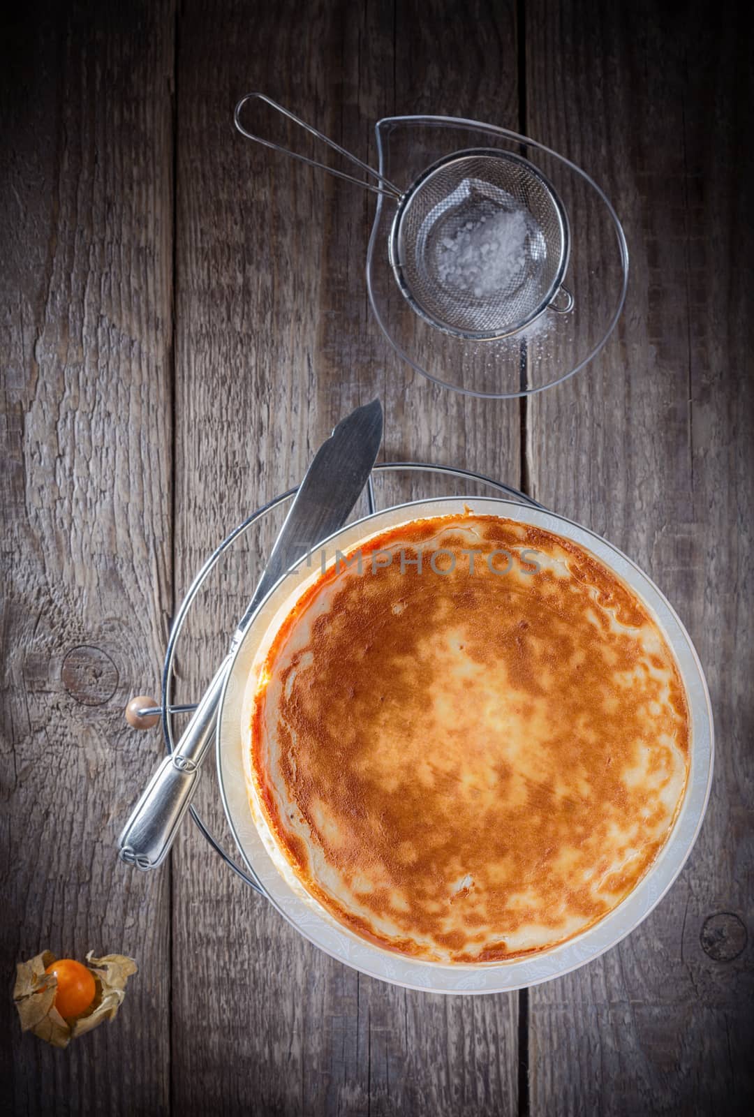 Homemade Cheesecake with a knife on a wooden surface