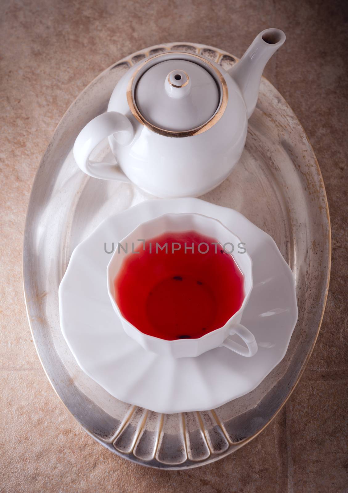 A cup of Red fruit tea with a kettle