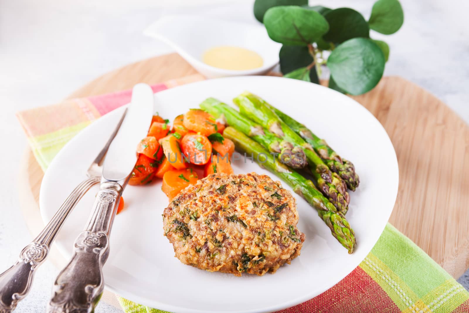 Meat rissole with glazed carrots, asparagus on the plate 