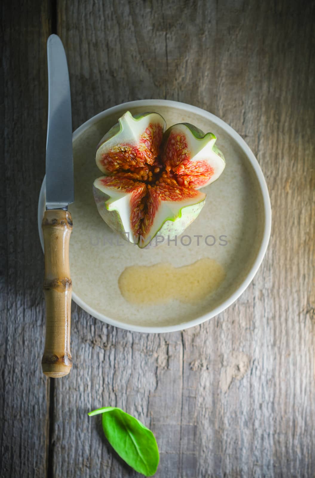 Fresh Juicy fig with a knife on the plate