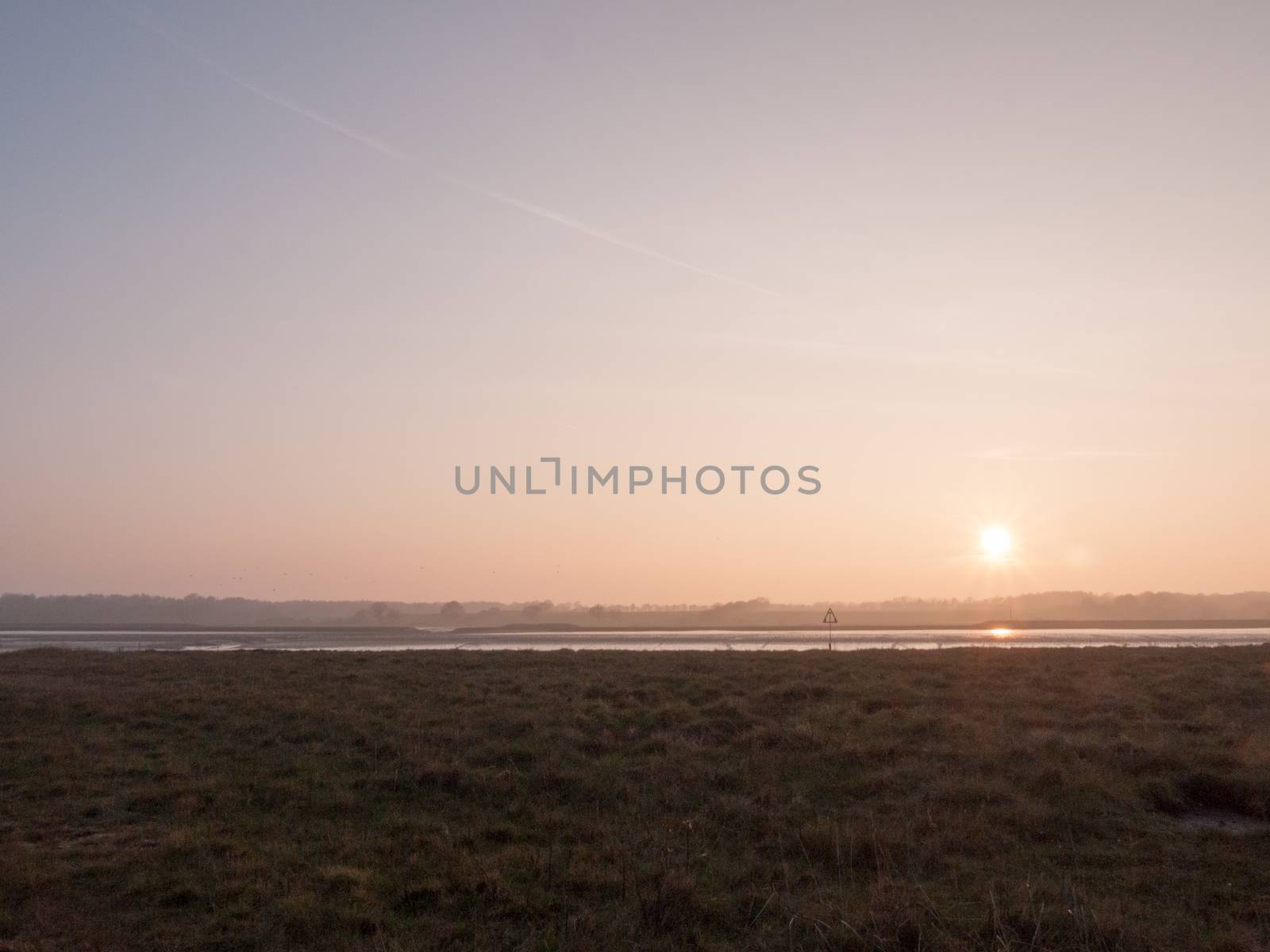 Various shots of the river and the mud, along with many birds, buoys, and other sea structures, as the sun sets