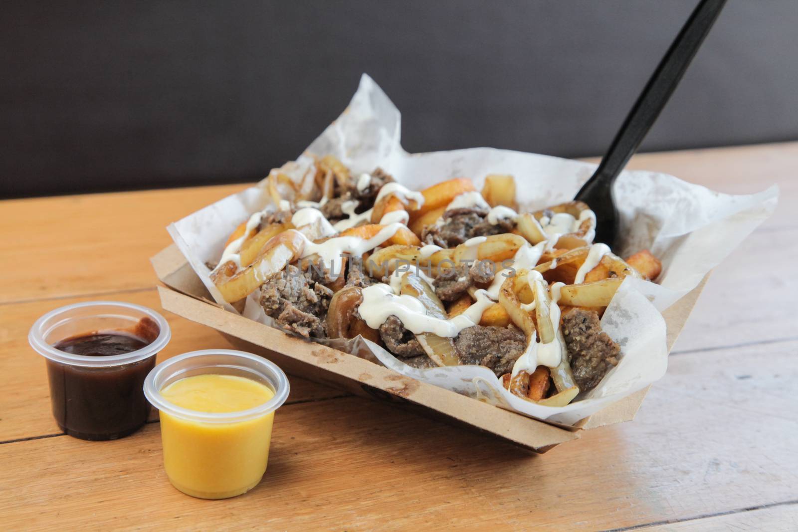 Poutine Curly fries with beef meat topped with cheese and mayo

