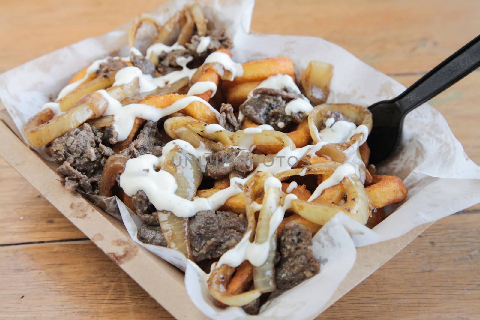 Poutine Curly fries with beef meat topped with cheese and mayo

