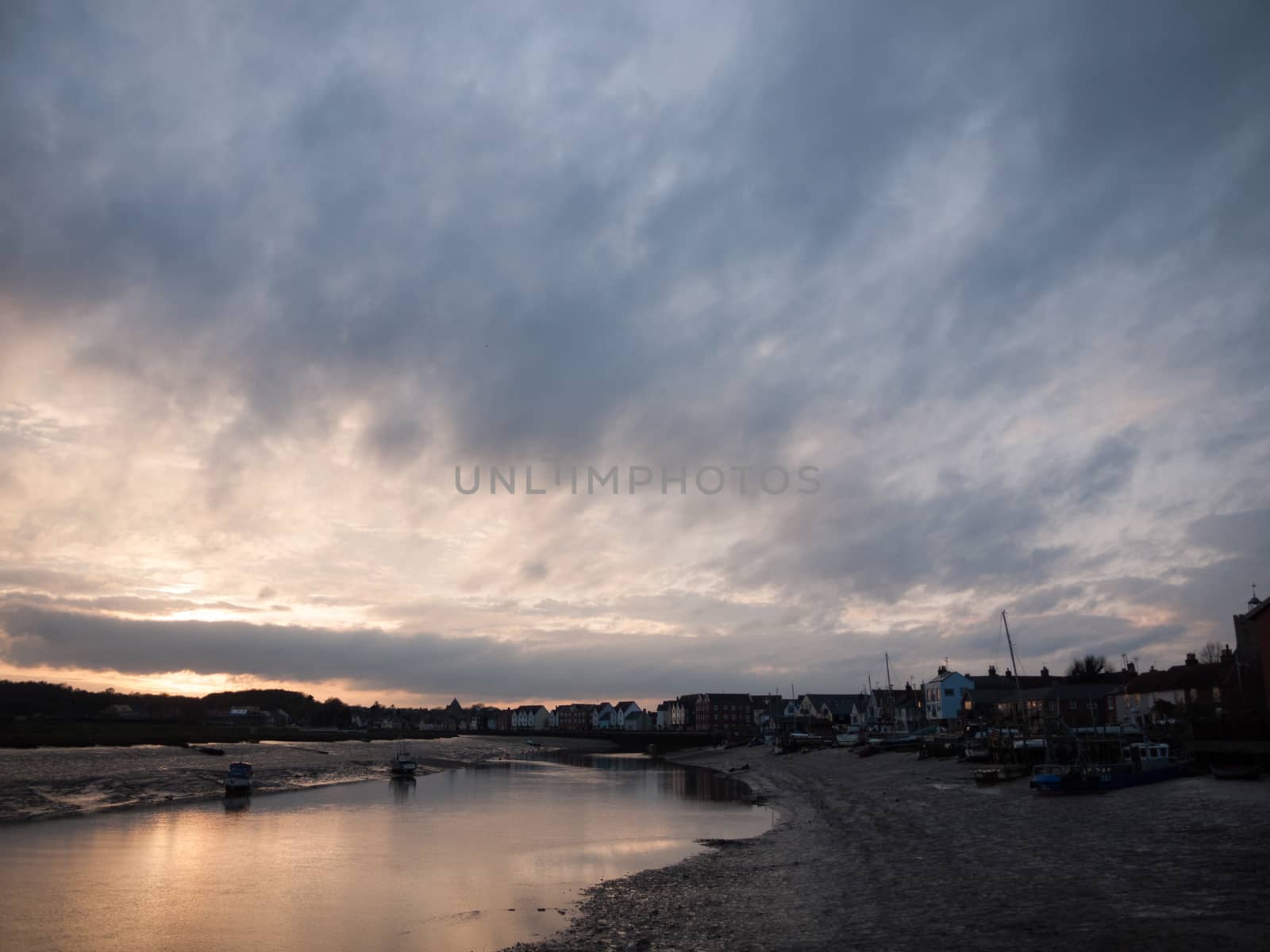 Low tide river with boats, a pier and more