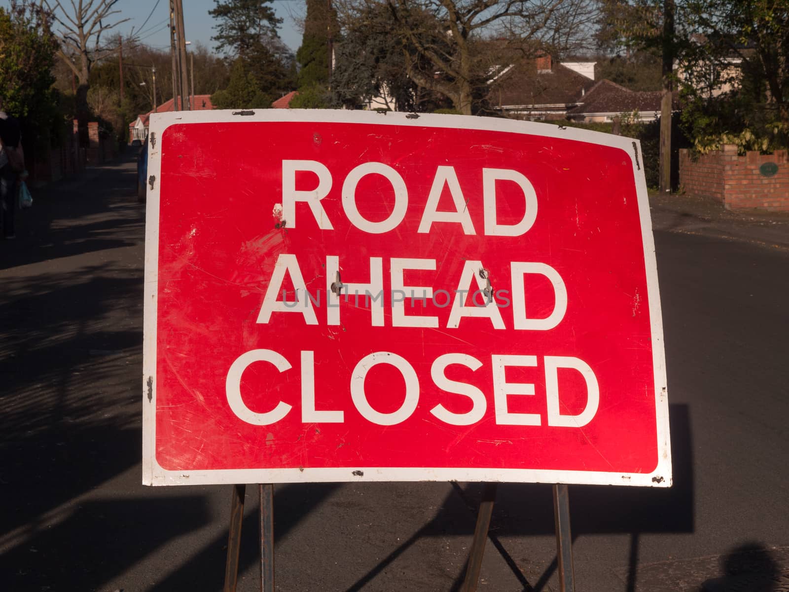 A a big red and white road closed ahead sign