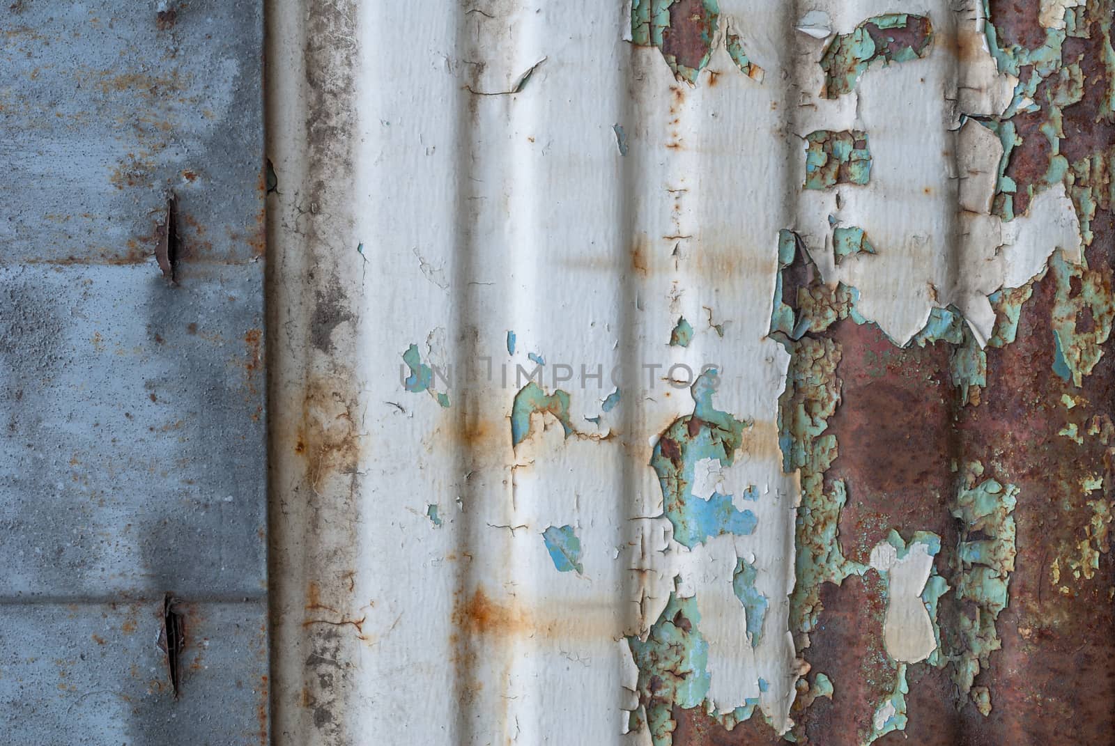 rusty iron surface covered with old chipped grey color paint, which has long been influenced by different climatic conditions