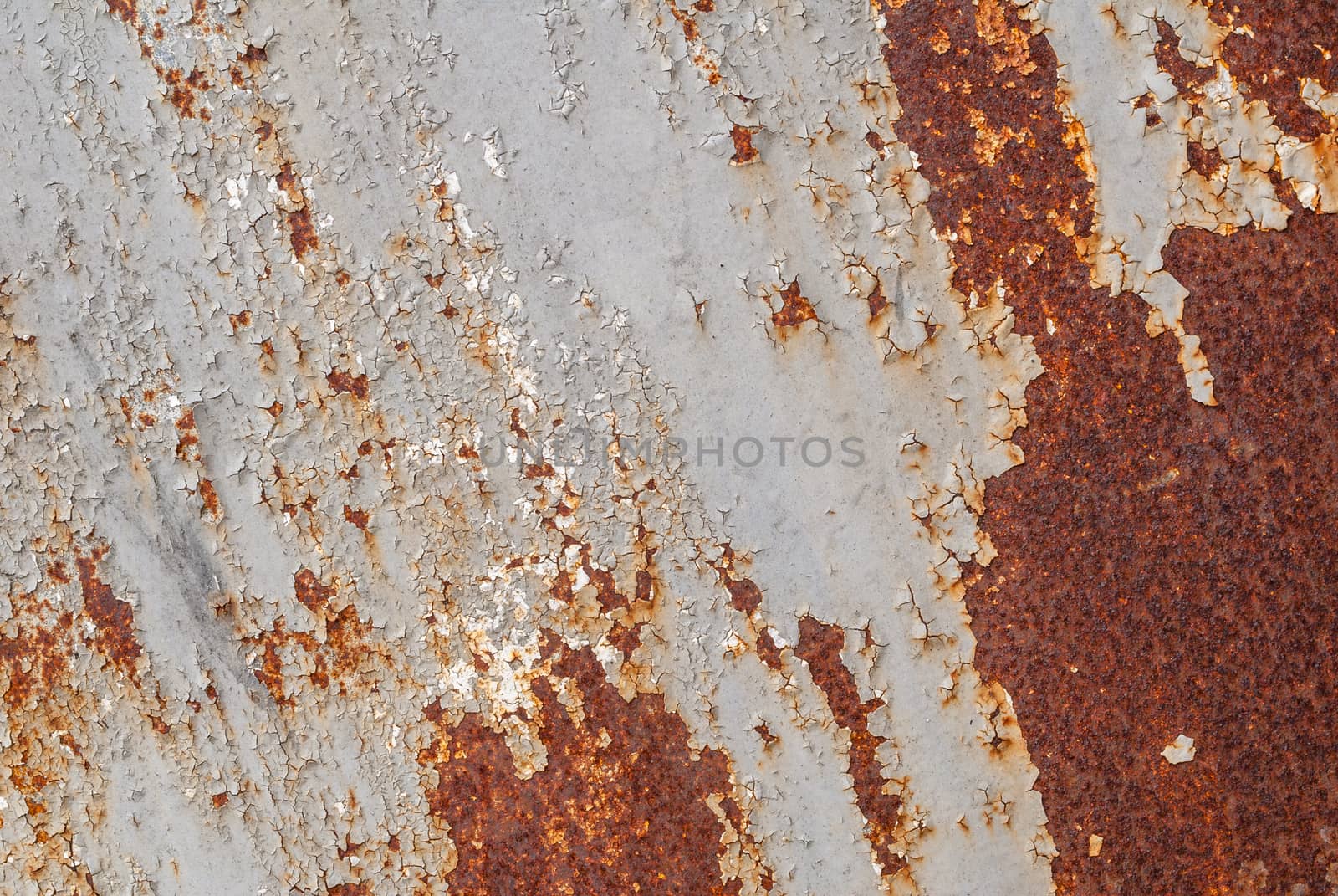 rusty iron surface covered with old chipped grey color paint, which has long been influenced by different climatic conditions