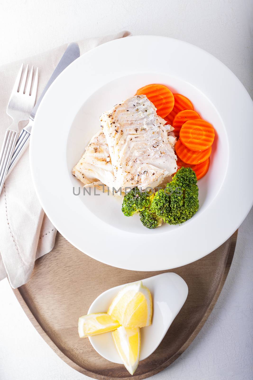 Healthy lunch with cod and steamed vegetables