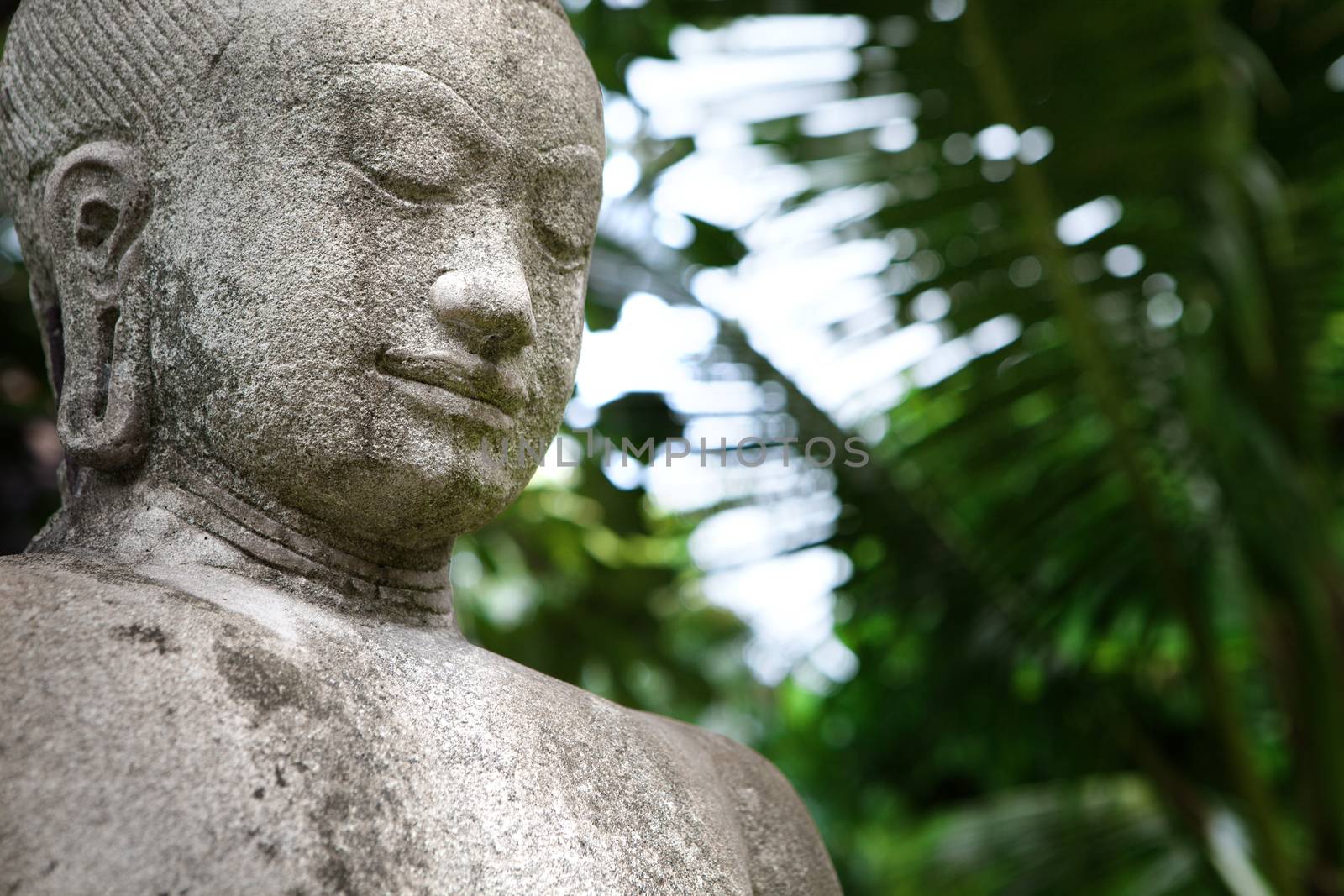 close up view of old concrete Buddha statue on green back