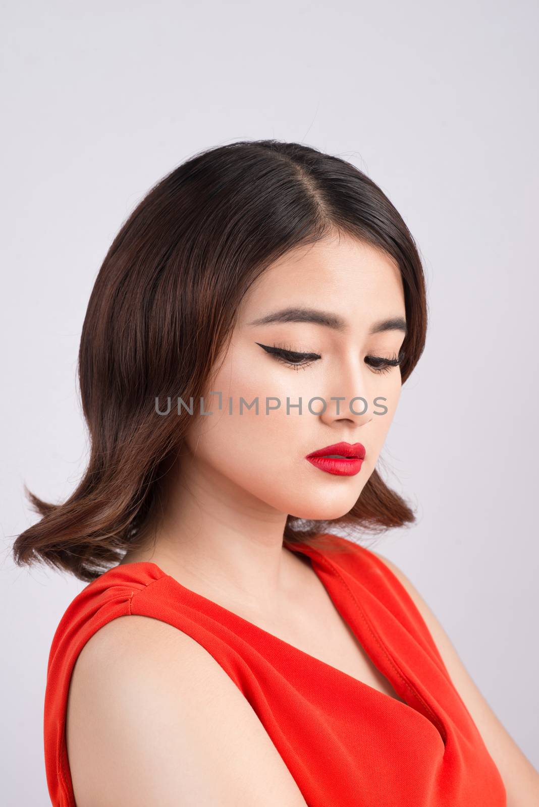 Fashion studio portrait of gorgeous sensual asian woman with dark hair wears elegant red dress