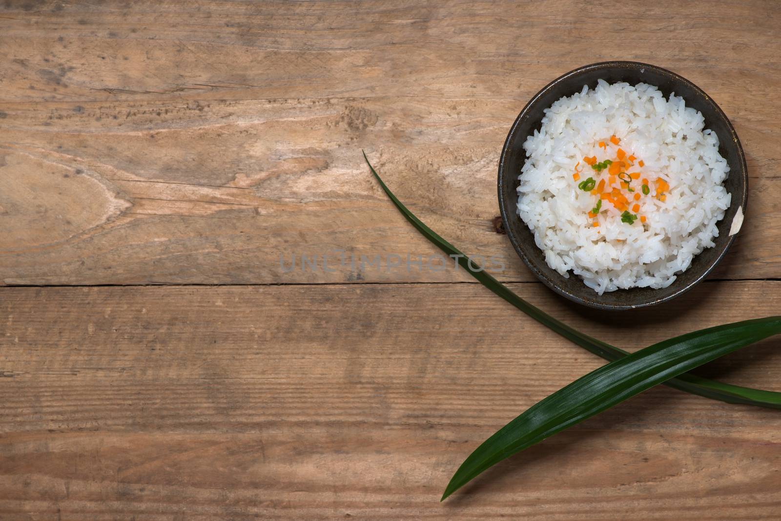 Boiled rice in a bowl on wooden table. by makidotvn