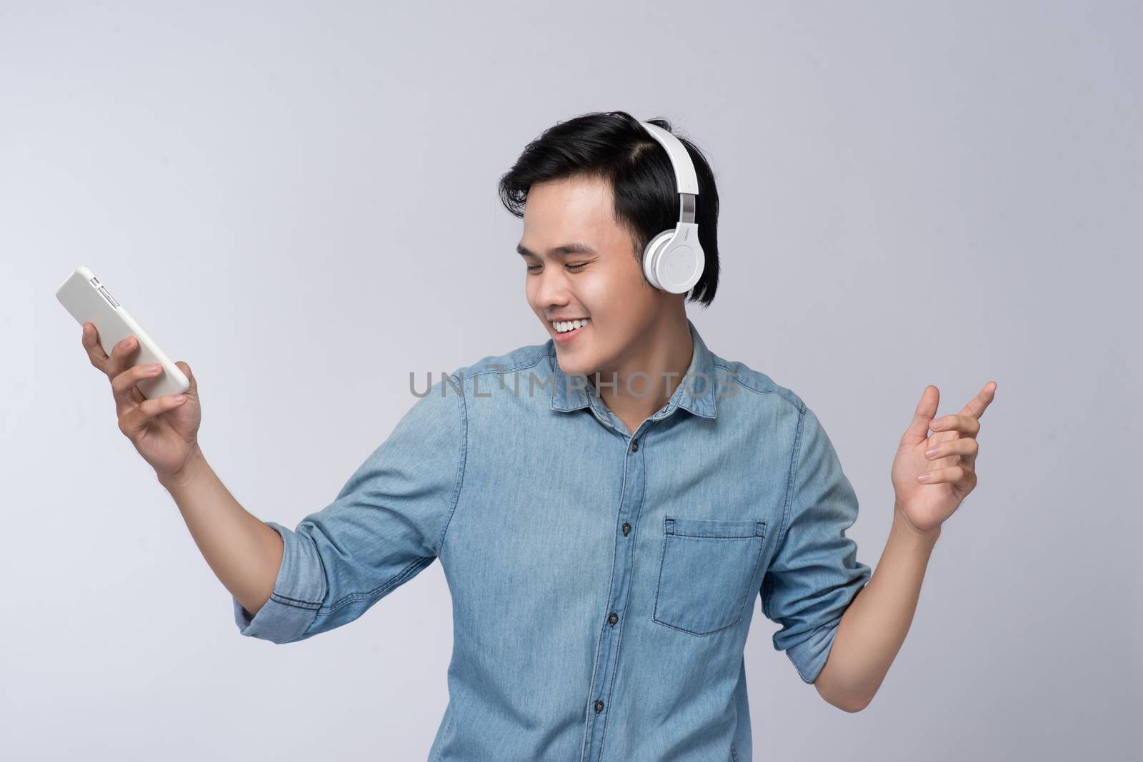 Smart casual asian man with headphone in studio background by makidotvn