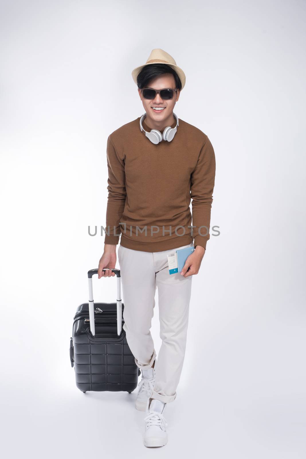 Full length of young tourist asian man holding passport with sui by makidotvn