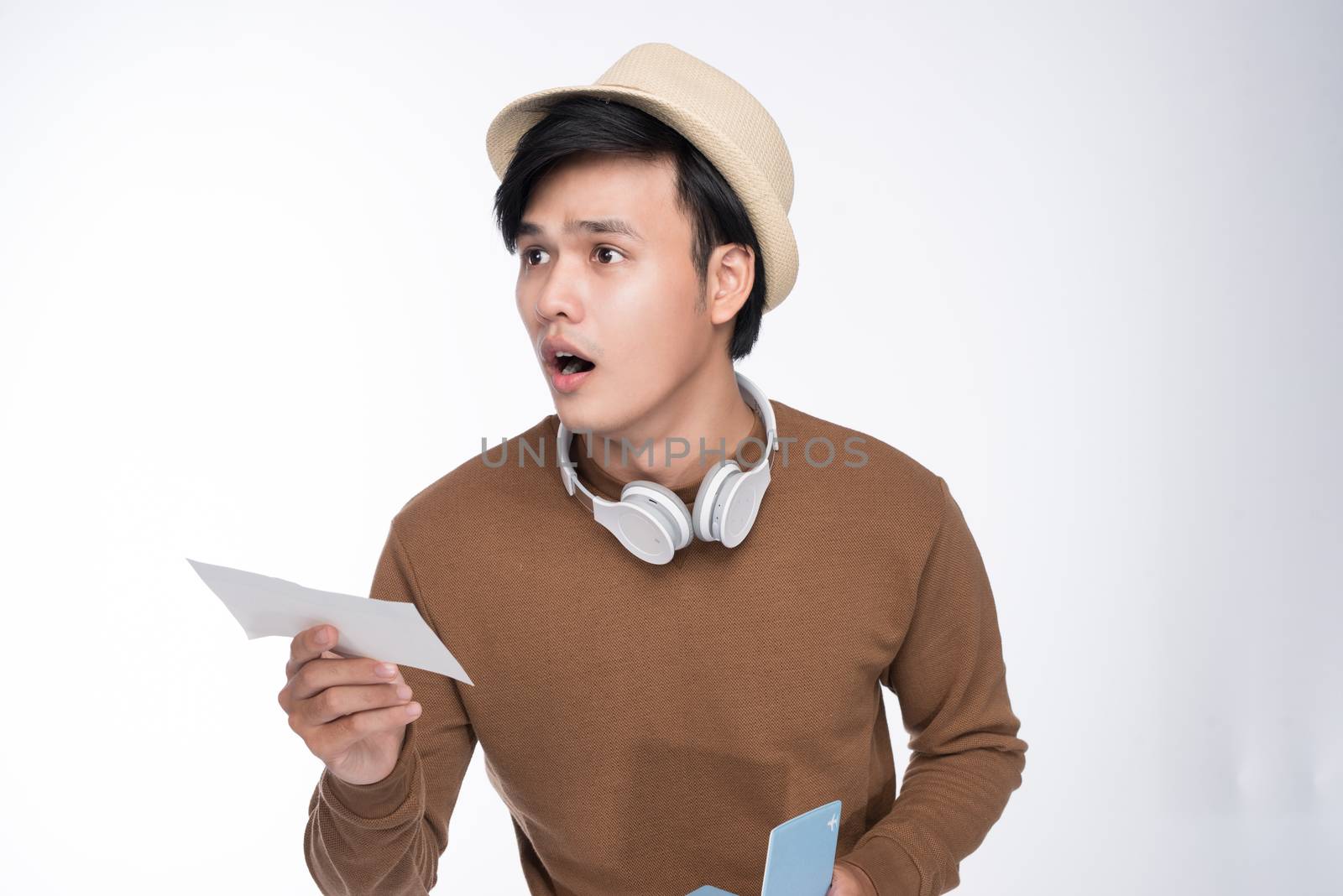 Happy young tourist asian man holding passport over grey background