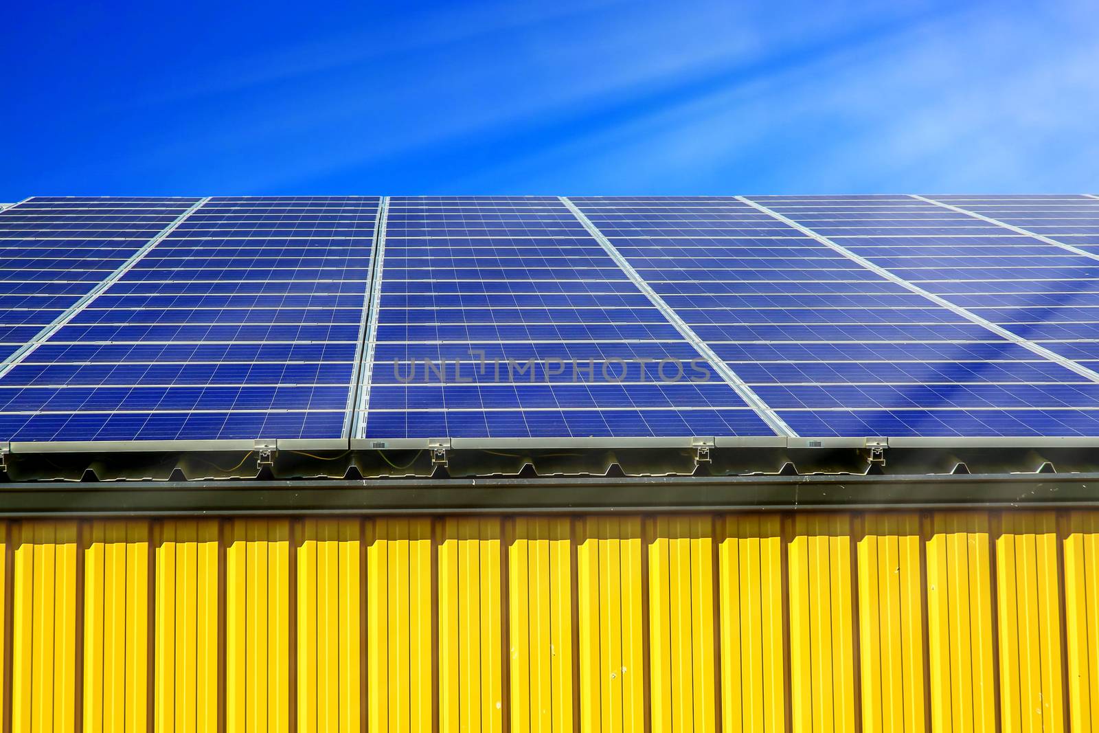 Solar panel on a roof of commercial warehouse by pixinoo