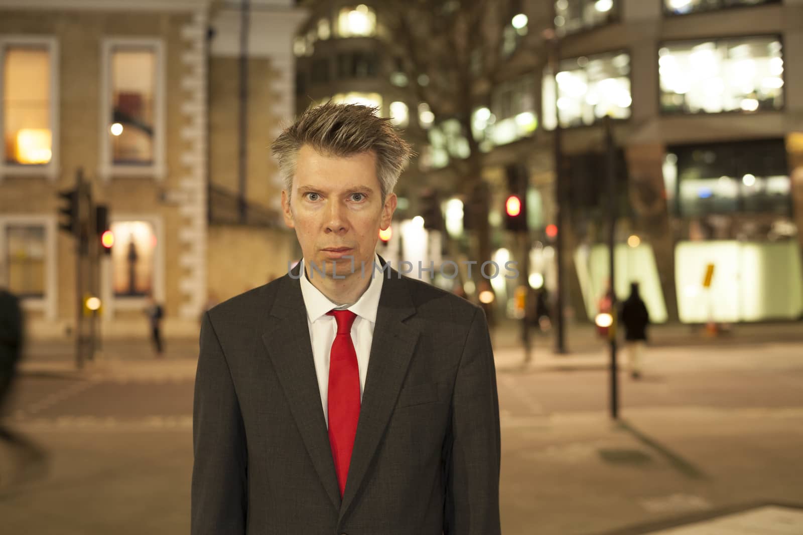 Businessman standing still at night themes of departure leaving rush hour