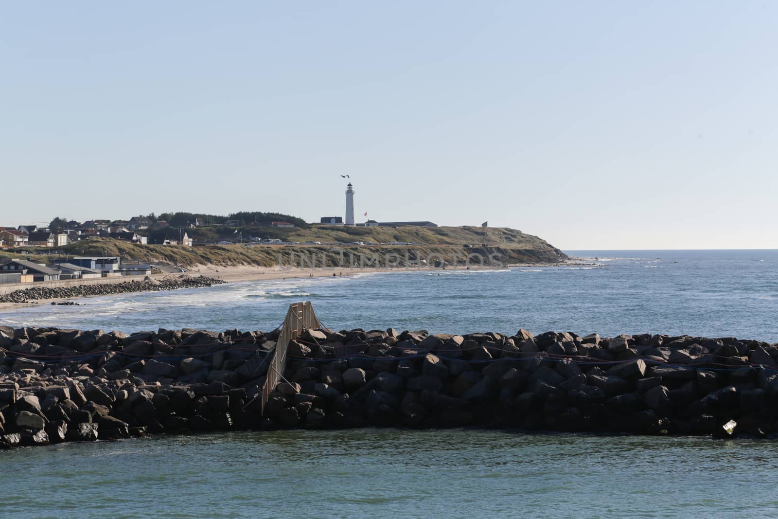 The coastline of Hirtshals and a lighthouse in the background
