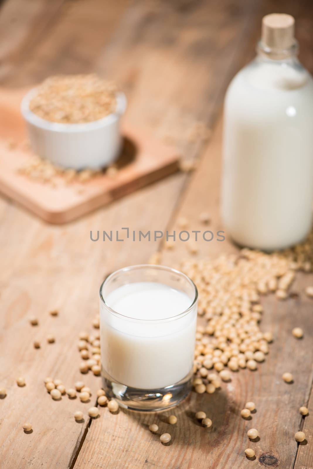 Soy milk or soya milk and soy beans on wooden table.  by makidotvn