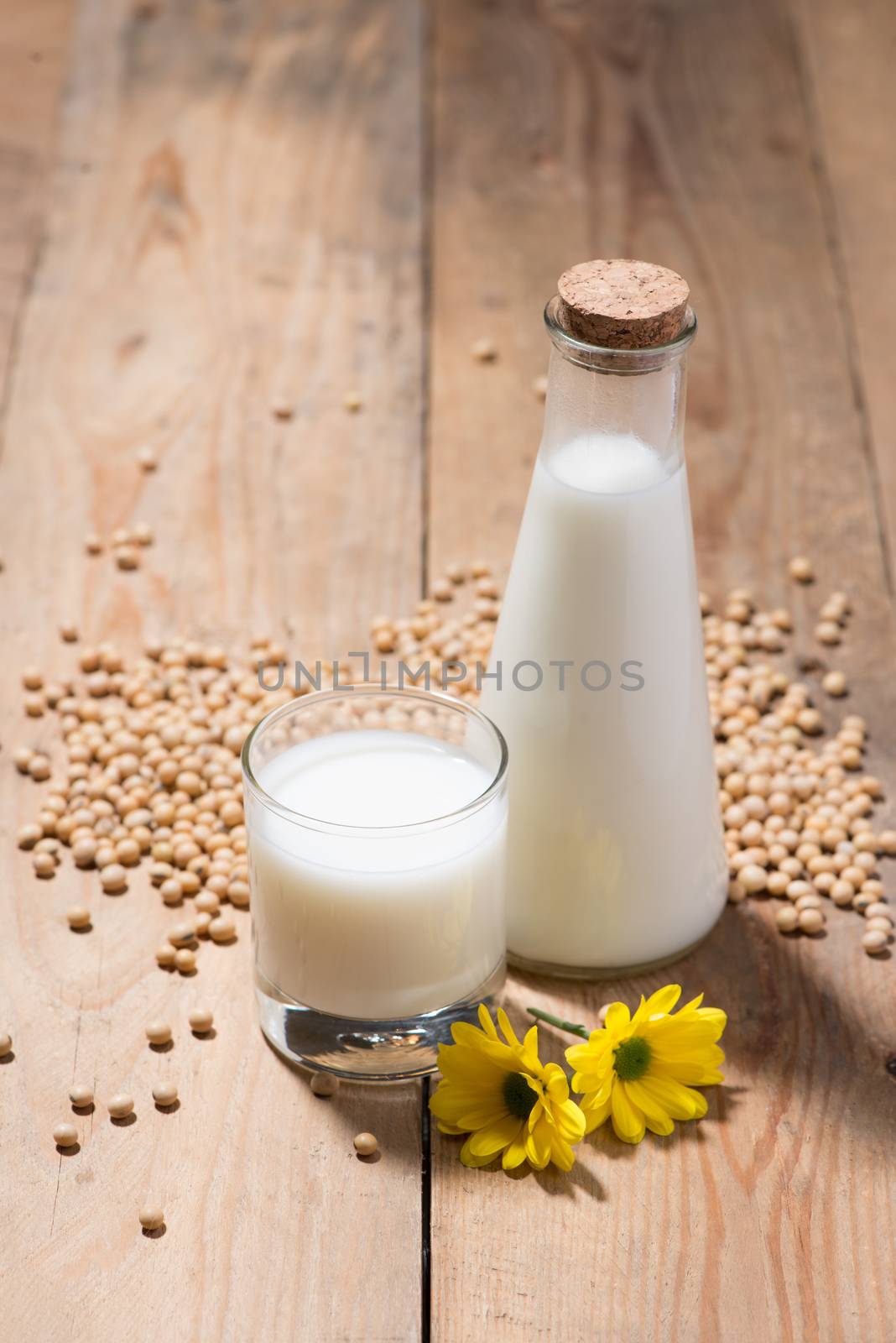 Soy milk or soya milk and soy beans in spoon on wooden table. 