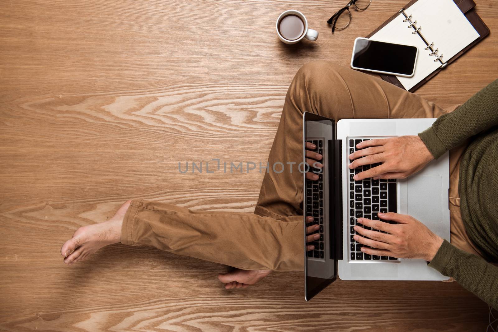 Business man hands using a laptop with a cup of coffee and smart phone with copy space.
