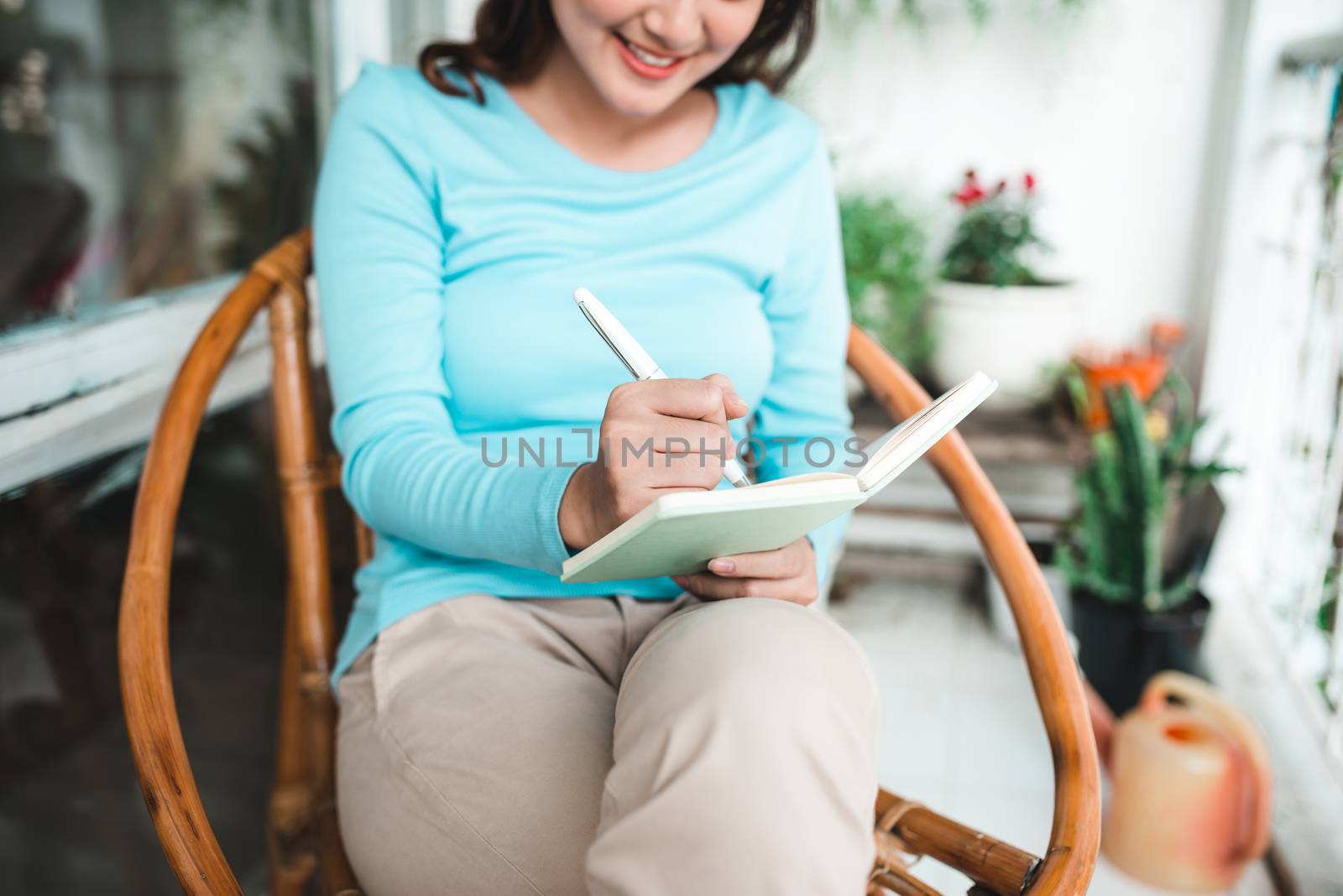 Beautiful asian woman at home writing and working with diary
